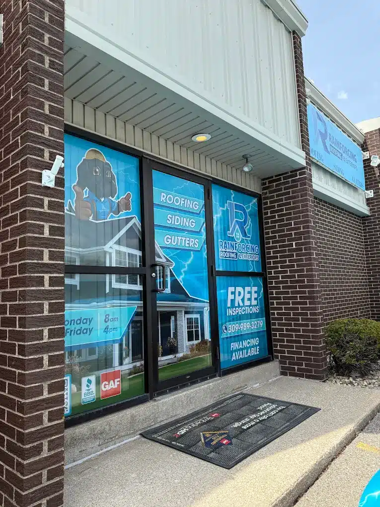 The professional glass storefront entrance of Rainforcing Roofing & Exteriors in Peoria, IL, displaying service offerings, financing availability, and GAF and BBB accreditation logos